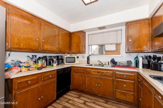 a kitchen with a sink a stove cabinets and wooden floor