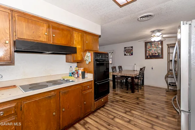 a kitchen with stainless steel appliances granite countertop a refrigerator and a stove top oven
