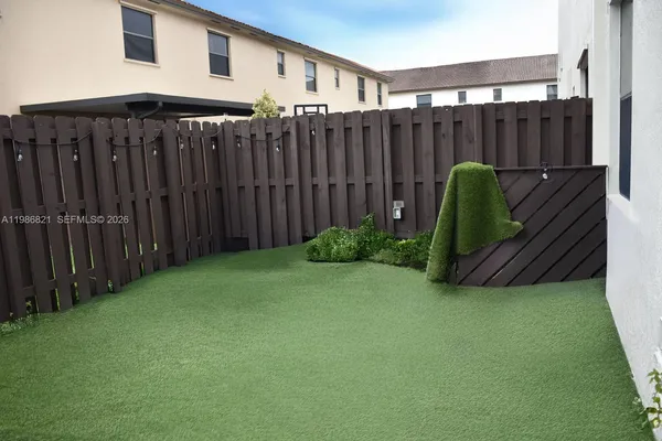 a view of a backyard with wooden fence