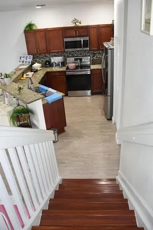 a kitchen with stainless steel appliances wooden floors and wooden cabinets