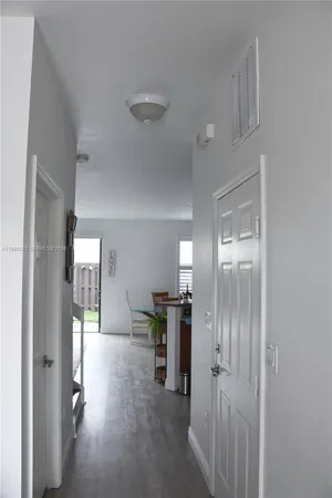 a view of a hallway with wooden floor windows and livingroom