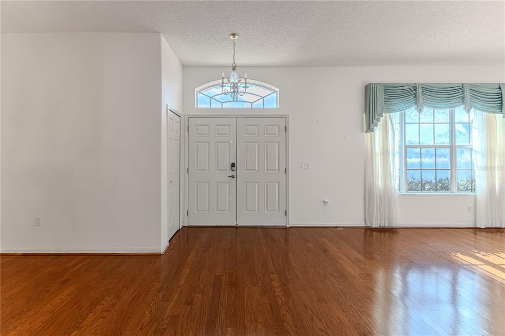 239 Longleaf Court Spring Hill, FL 34609 - Photo 6 of 55 wooden floor in an empty room with a window