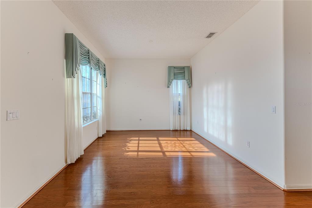 239 Longleaf Court Spring Hill, FL 34609 - Photo 8 of 55 an empty room with wooden floor and windows