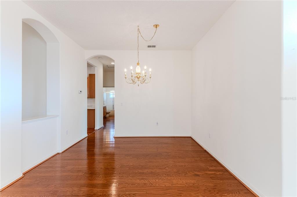 239 Longleaf Court Spring Hill, FL 34609 - Photo 10 of 55 a view of a room with wooden floor and chandelier