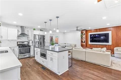 a kitchen with stainless steel appliances kitchen island granite countertop a stove and a sink
