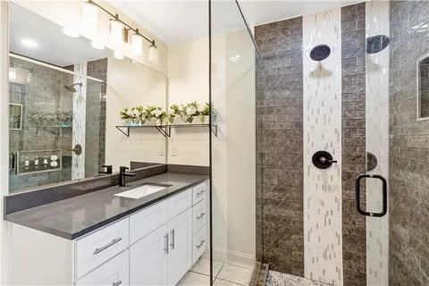 a bathroom with a granite countertop sink a shower and a mirror