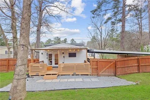 a view of a house with backyard and a tree