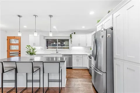 a kitchen with stainless steel appliances granite countertop a refrigerator and a stove top oven