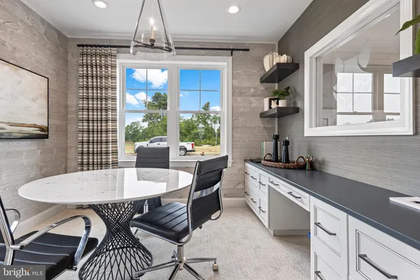 a kitchen with a dining table chairs and white cabinets