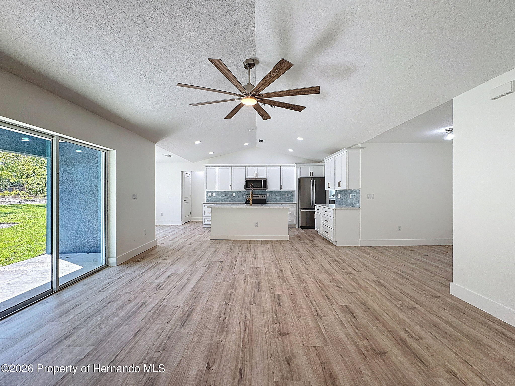 8988 Waterbird Way Weeki Wachee, FL 34613 - Photo 11 of 42 a view of a kitchen with a sink and wooden floor