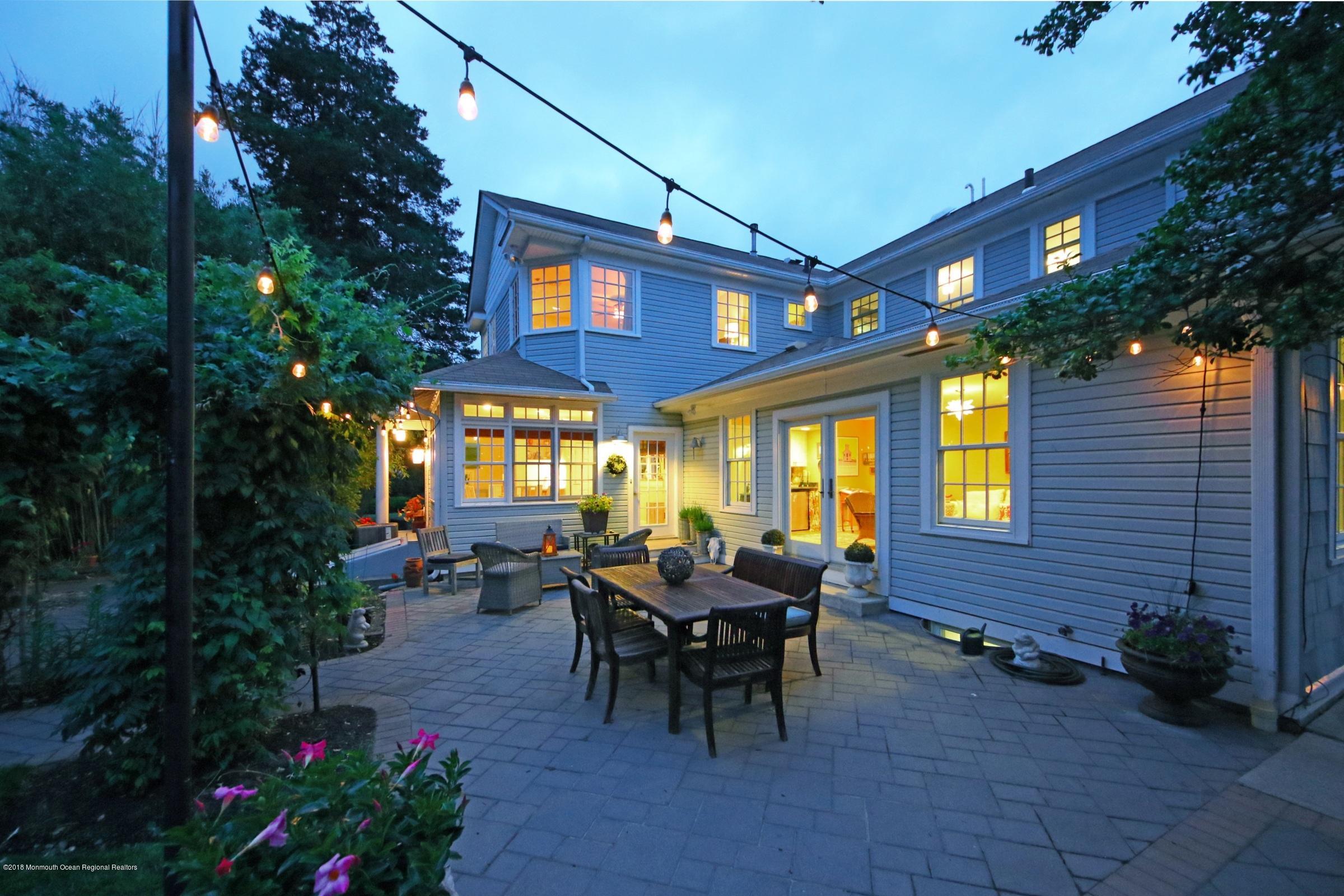 668 River Road Fair Haven, NJ 07704 - Photo 62 of 68 a view of a patio with table and chairs potted plants and floor to ceiling window