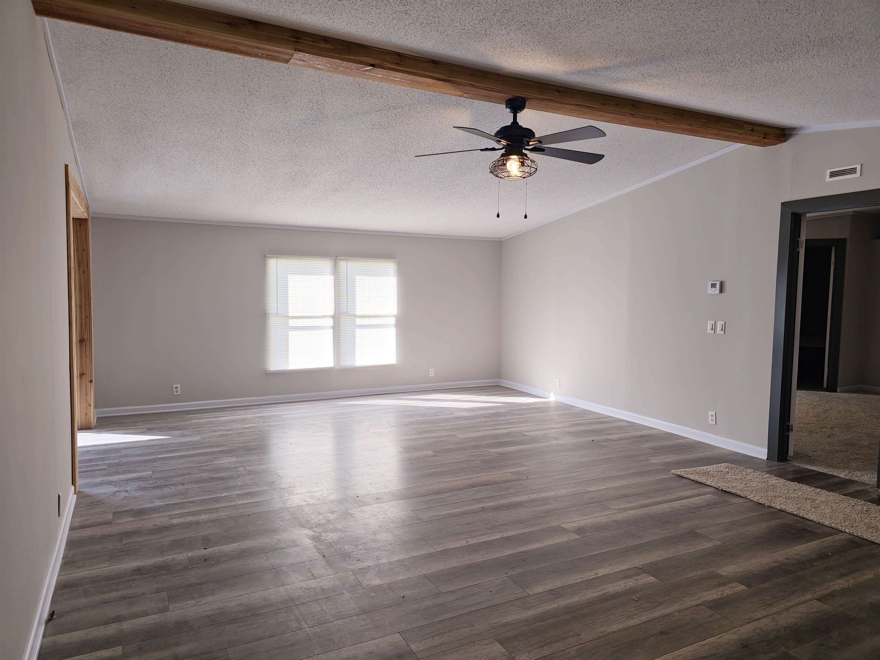 1564 Fayne Road Brighton, TN 38011 - Photo 3 of 11 Spare room featuring dark hardwood / wood-style floors, beamed ceiling, ceiling fan, and a textured ceiling