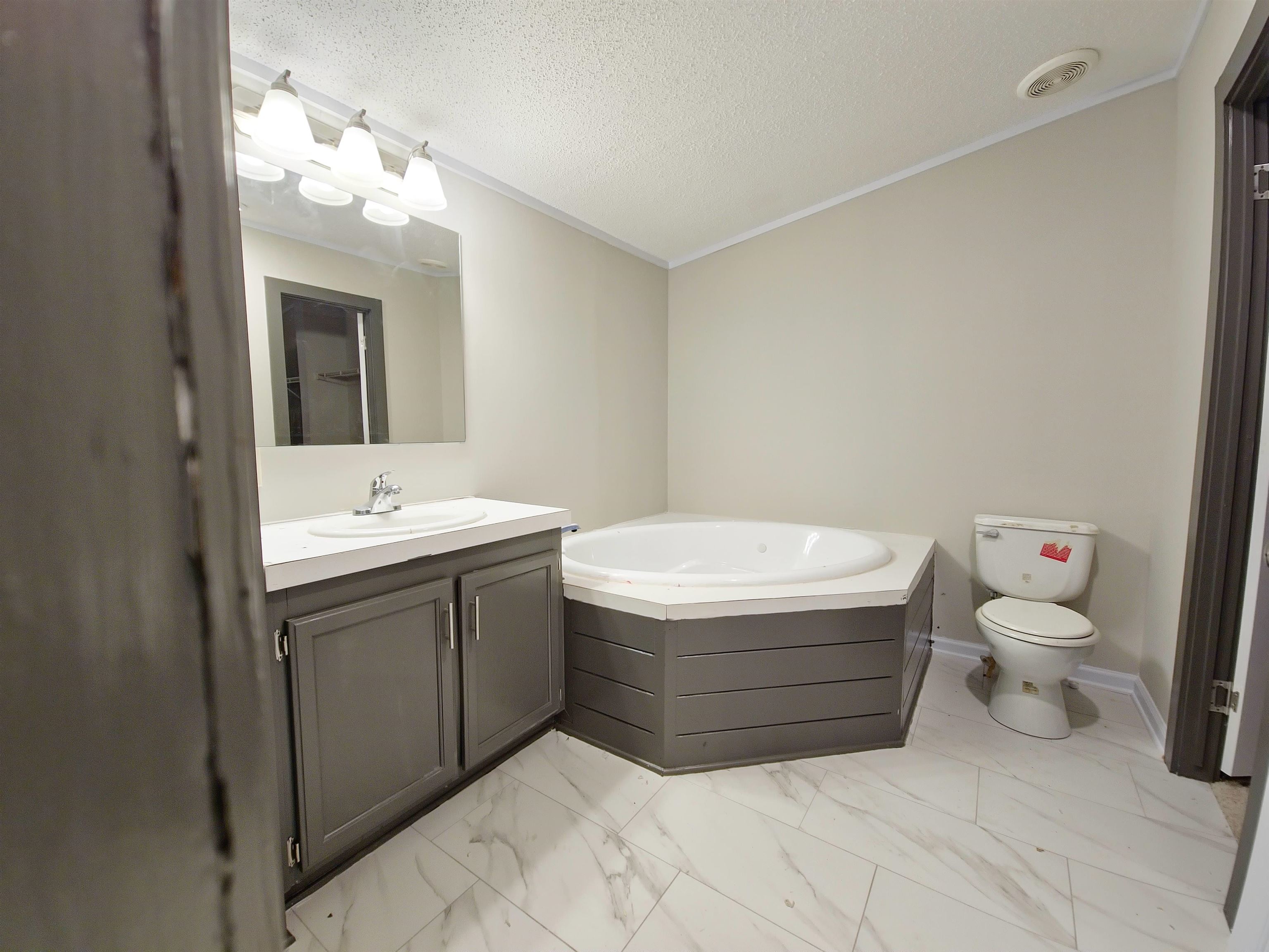 1564 Fayne Road Brighton, TN 38011 - Photo 7 of 11 Bathroom featuring toilet, tile flooring, a bathtub, vanity, and a textured ceiling