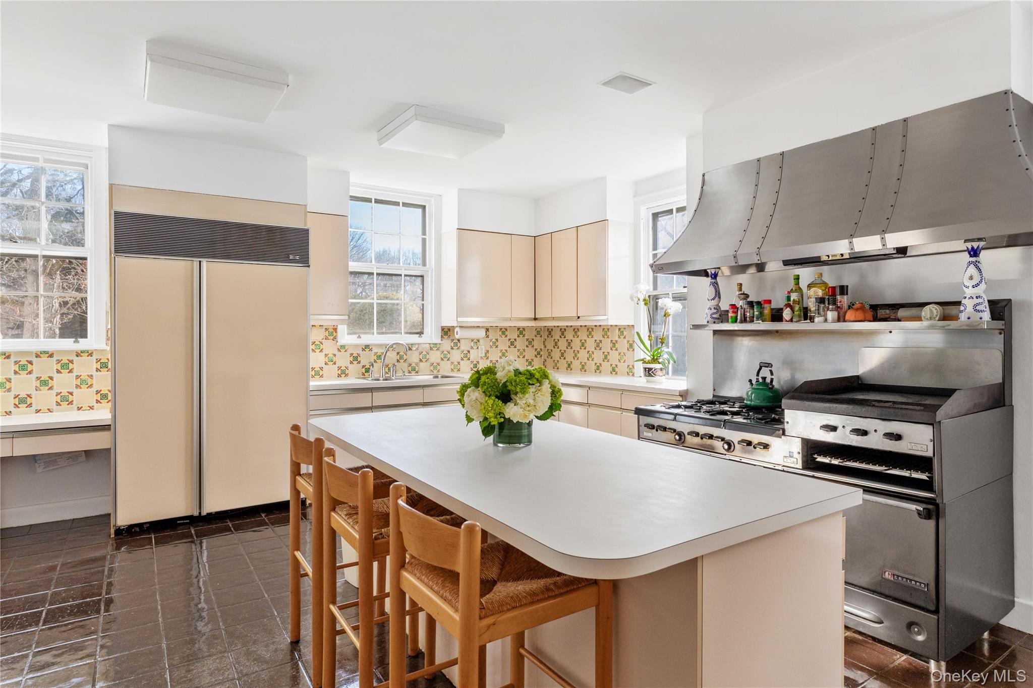 10 Lands End Road Locust Valley, NY 11560 - Photo 20 of 22 a kitchen with kitchen island a stove a table and chairs in it