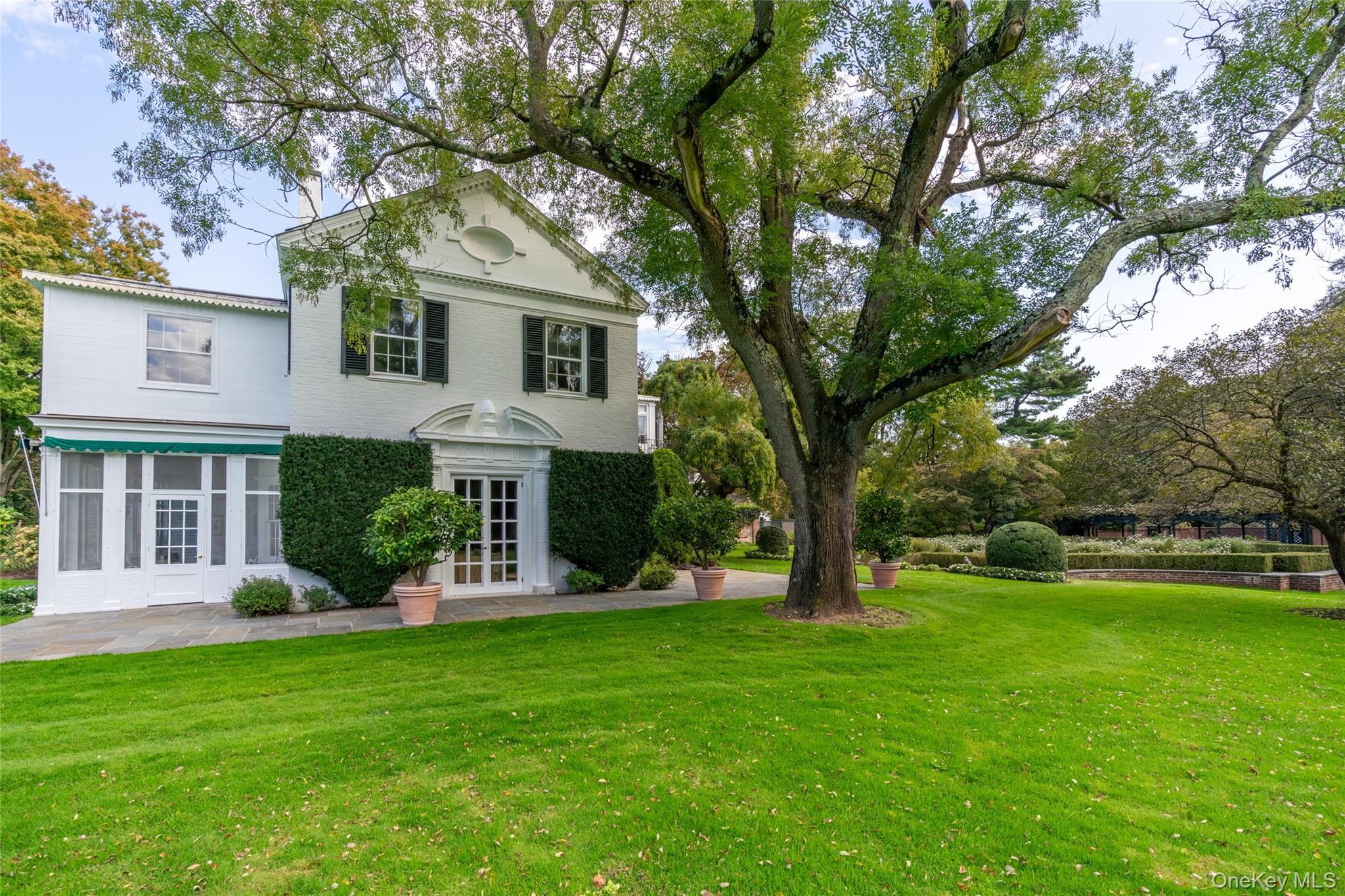 10 Lands End Road Locust Valley, NY 11560 - Photo 22 of 23 a front view of a house with garden and trees