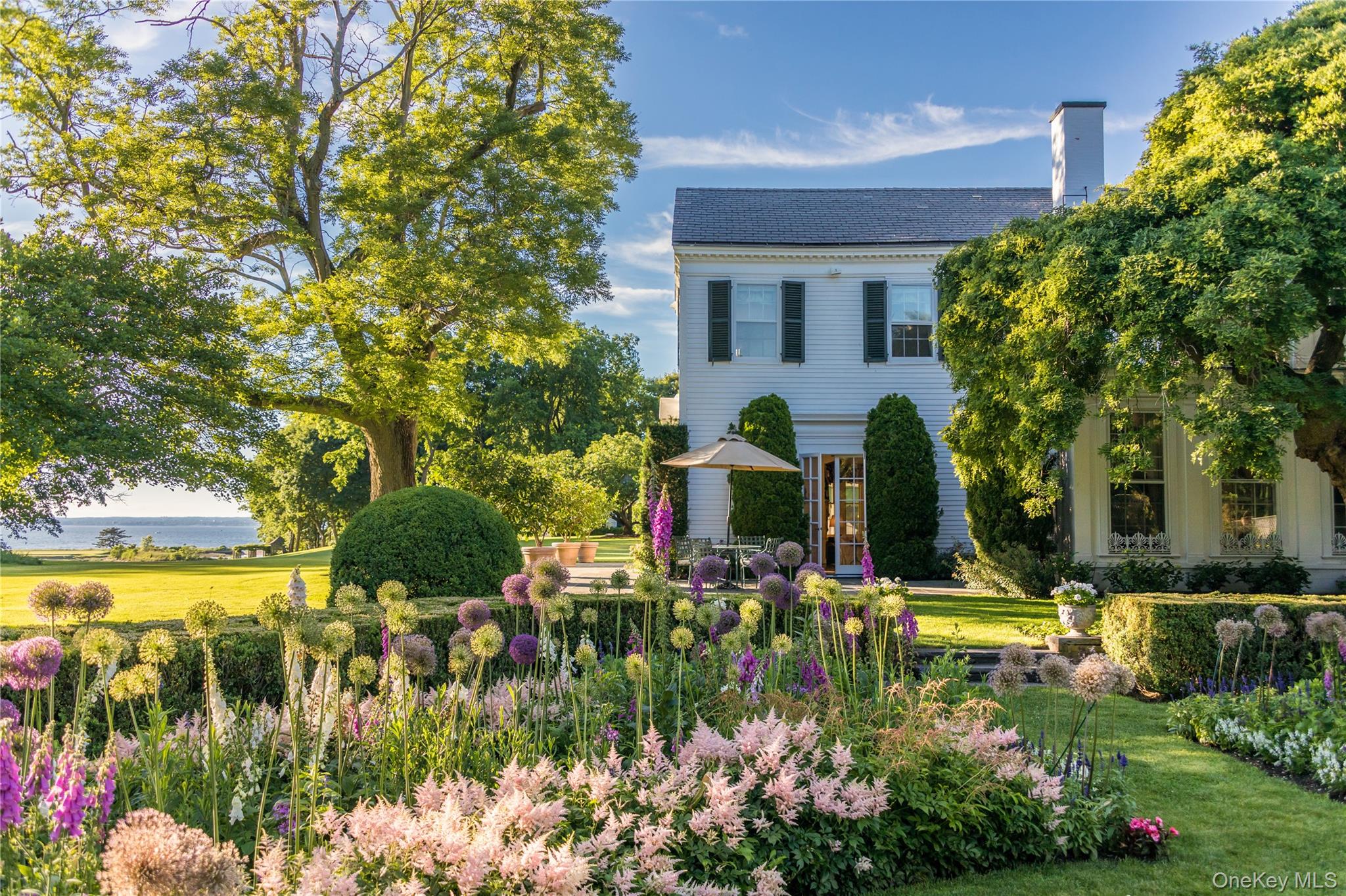 10 Lands End Road Locust Valley, NY 11560 - Photo 5 of 23 a front view of a house with swimming pool and green space