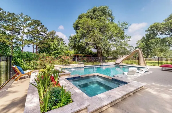 a view of a swimming pool with a patio and a garden