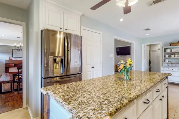 a kitchen with kitchen island sink and refrigerator