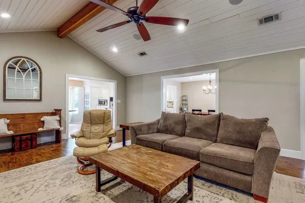 a living room with furniture and a wooden floor