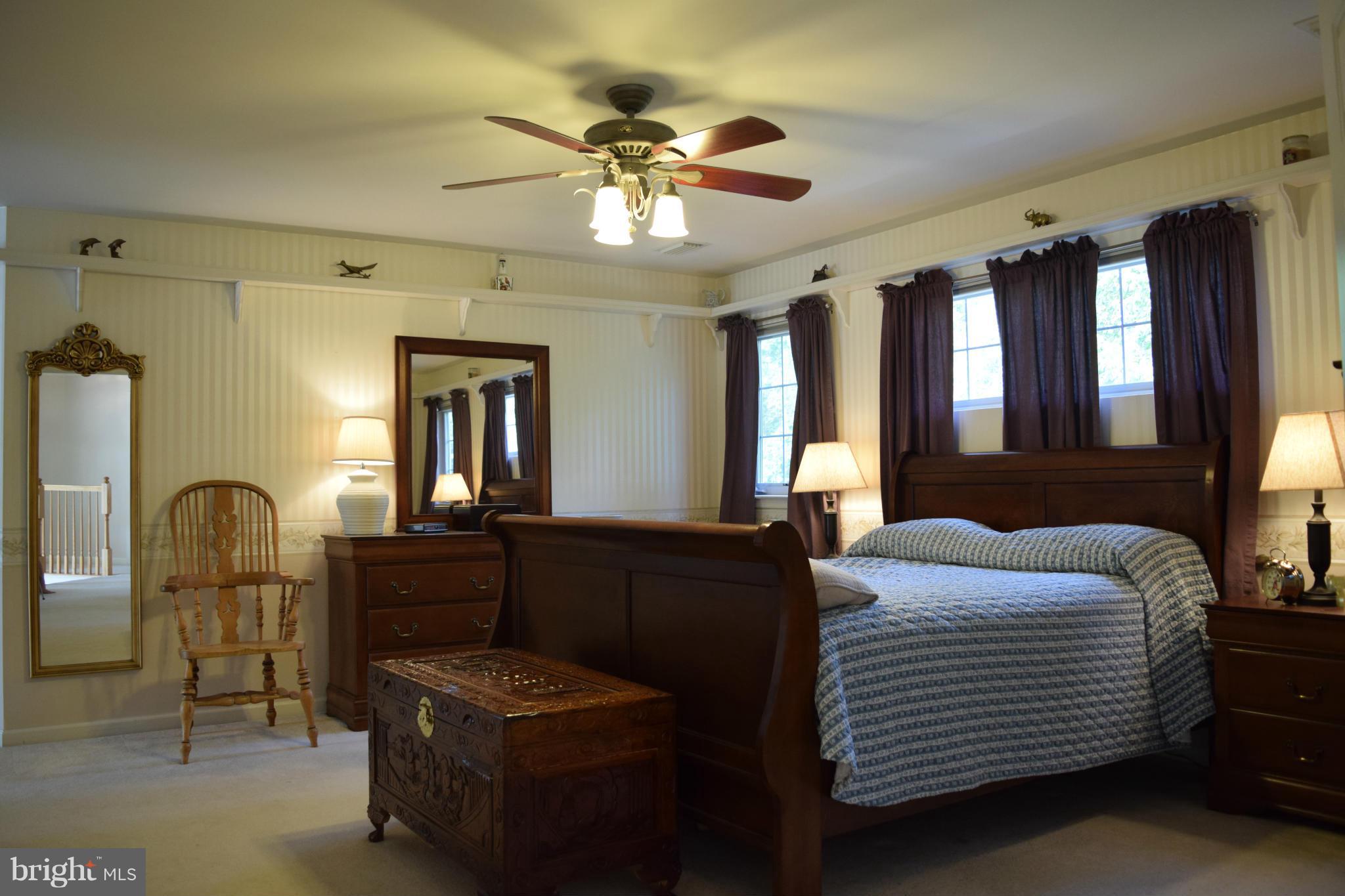 6001 Sandy Ridge Elkridge, MD 21075 - Photo 22 of 30 a bedroom with a bed and a chandelier