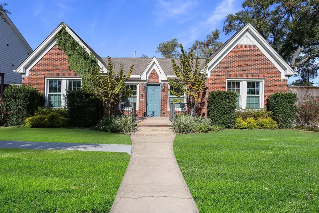 a front view of a house with a yard and trees