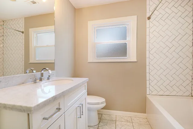 a bathroom with a sink a toilet and a mirror
