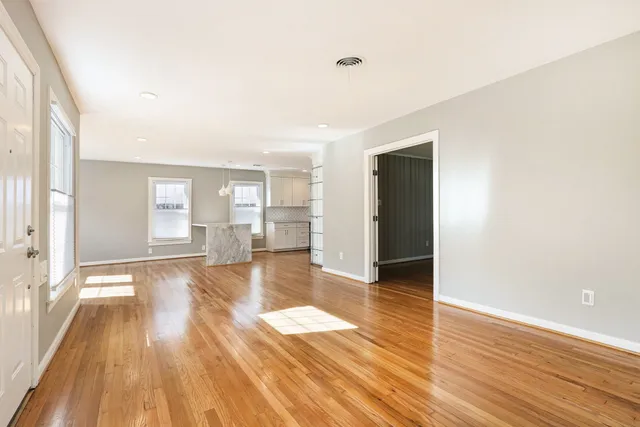 a view of empty room with wooden floor