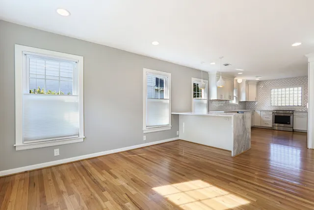 a view of a kitchen with wooden floor and a window