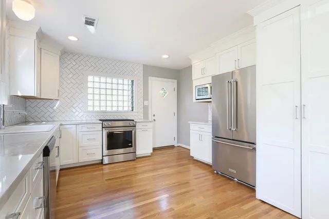a kitchen with a refrigerator and a stove top oven
