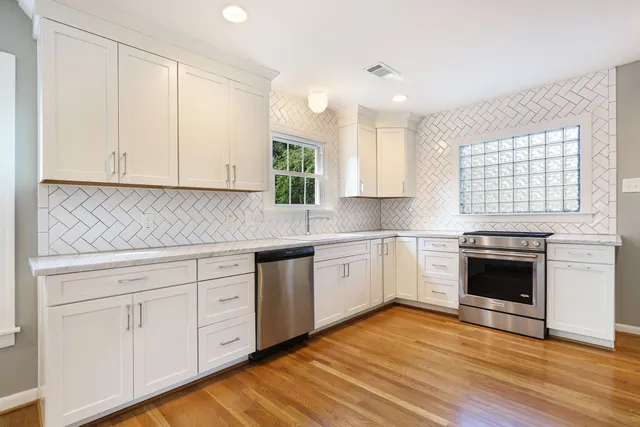 a kitchen with granite countertop white cabinets and white appliances