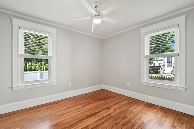 an empty room with wooden floor and windows