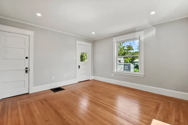 an empty room with window and wooden floor