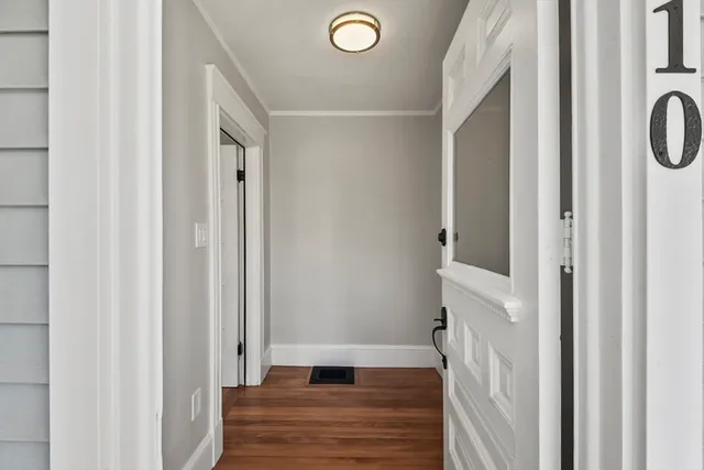 a view of a hallway with wooden floor and staircase