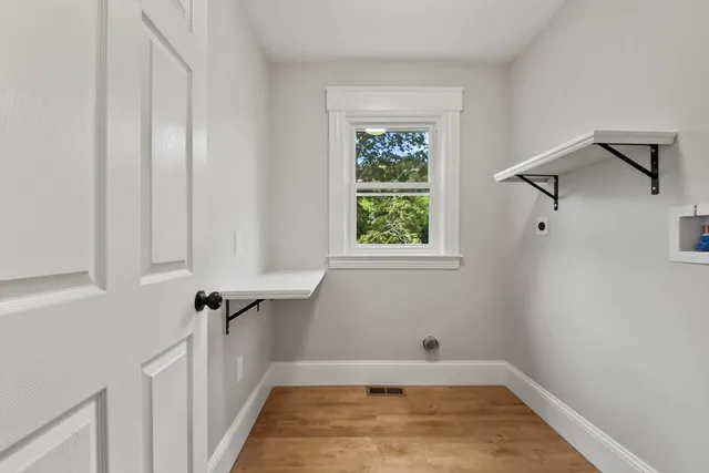 a view of a room with wooden floor and a window
