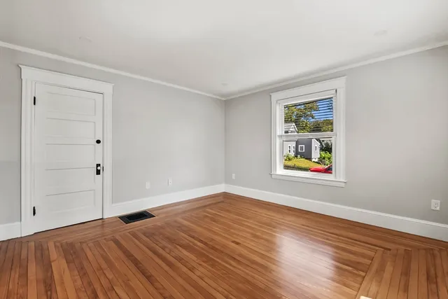 an empty room with window and wooden floor