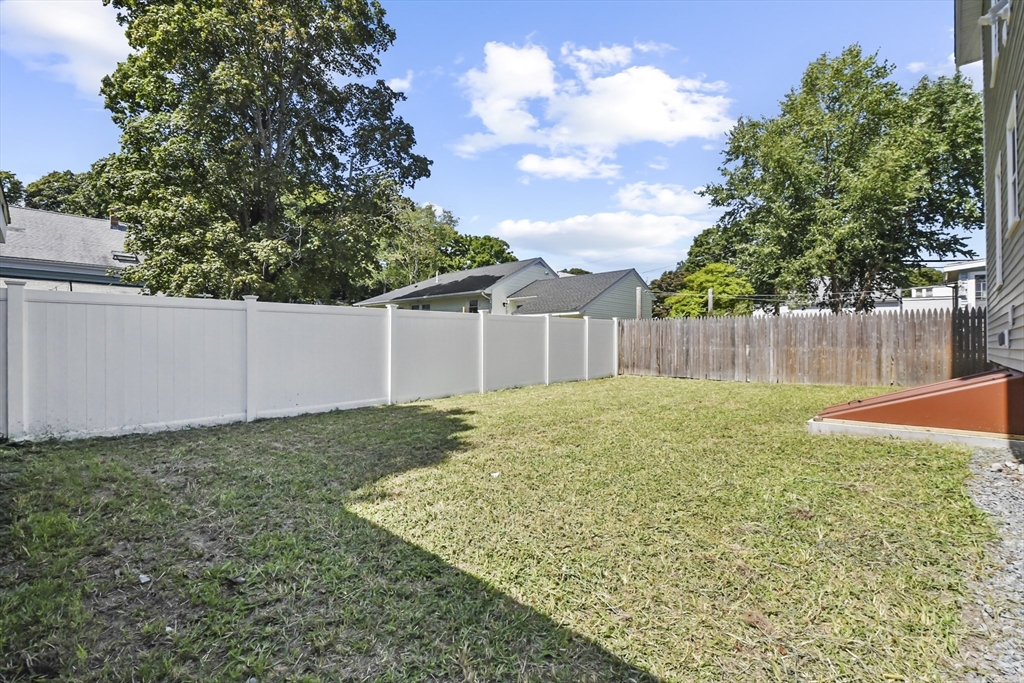 10 Cain Avenue, Unit 10 Weymouth, MA 02189 - Photo 31 of 34 a view of a backyard with grass and a tree