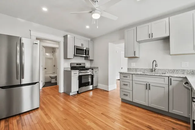 a kitchen with granite countertop a refrigerator stove top oven and sink