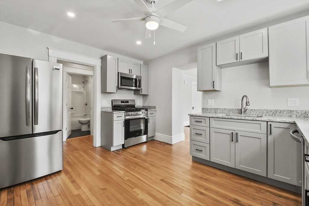 10 Cain Avenue, Unit 10 Weymouth, MA 02189 - Photo 7 of 34 a kitchen with granite countertop a refrigerator stove top oven and sink