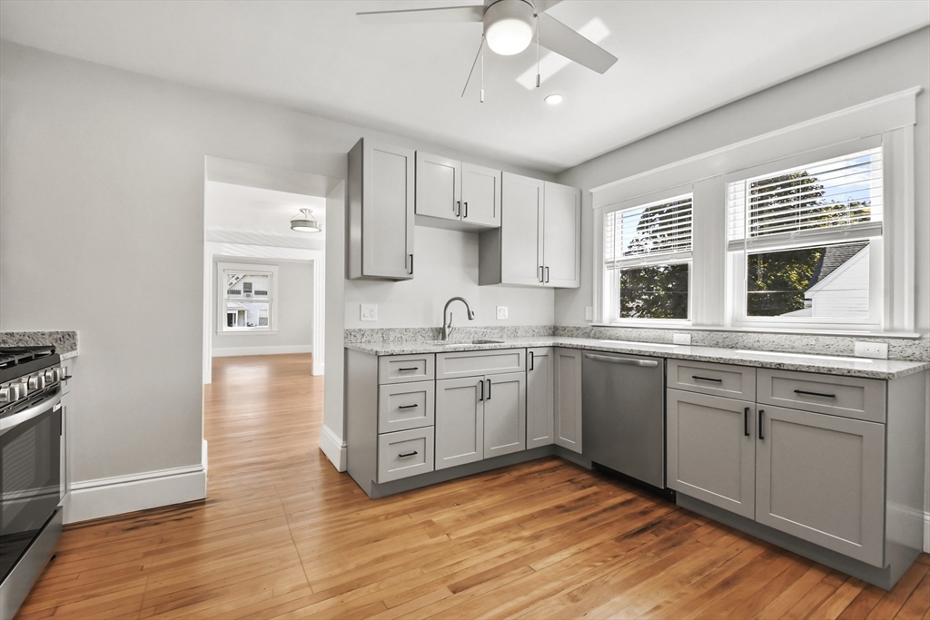 10 Cain Avenue, Unit 10 Weymouth, MA 02189 - Photo 9 of 34 a kitchen with stainless steel appliances granite countertop a sink cabinets and wooden floor