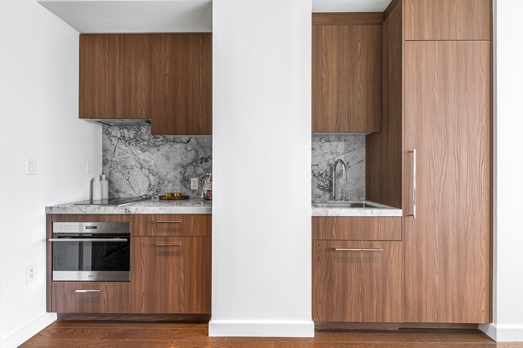 40 Trinity Place, Unit 1607 Boston, MA 02116 - Photo 5 of 36 a kitchen with granite countertop cabinets and window