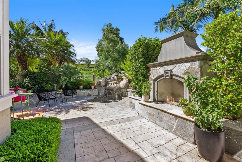 90 Cameray Heights Laguna Niguel, CA 92677 - Photo 7 of 36 a view of a patio with table and chairs potted plants and palm tree