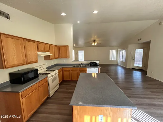 a kitchen with stainless steel appliances granite countertop a stove a sink and a refrigerator