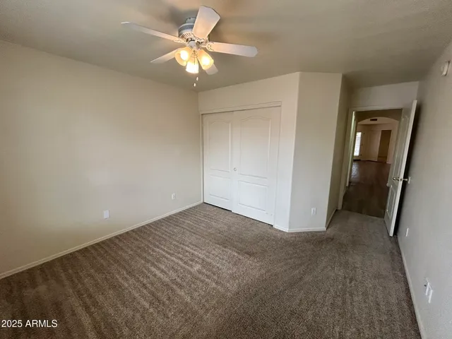 an empty room with a ceiling fan and a bathroom