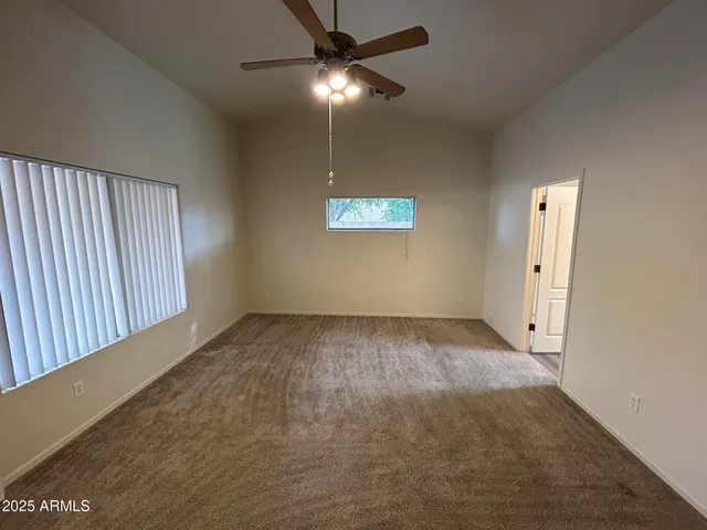an empty room with a ceiling fan and a window