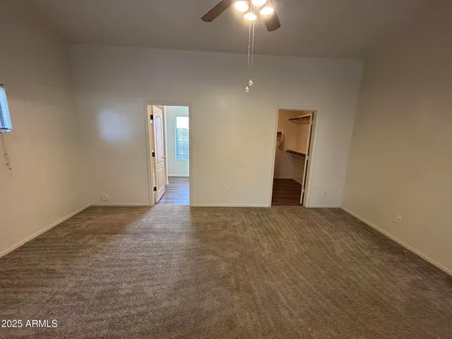 an empty room with closet and windows