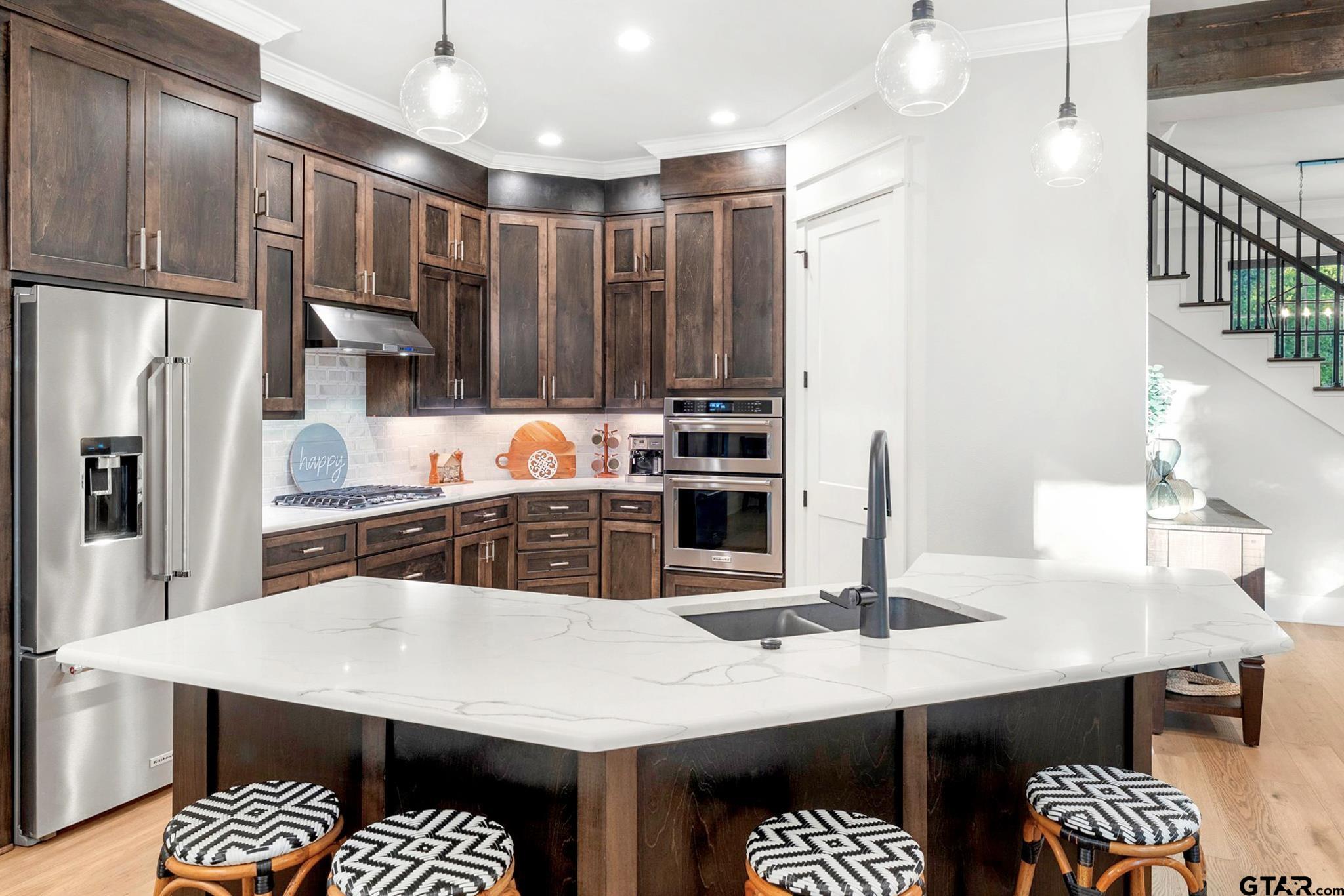 4301 Windrush Boulevard Longview, TX 75604 - Photo 13 of 36 a kitchen with stainless steel appliances kitchen island granite countertop a table chairs and a refrigerator