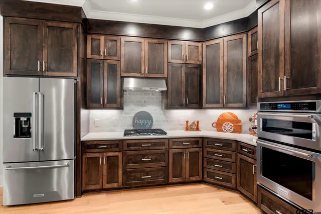 a kitchen with stainless steel appliances granite countertop a refrigerator and a stove