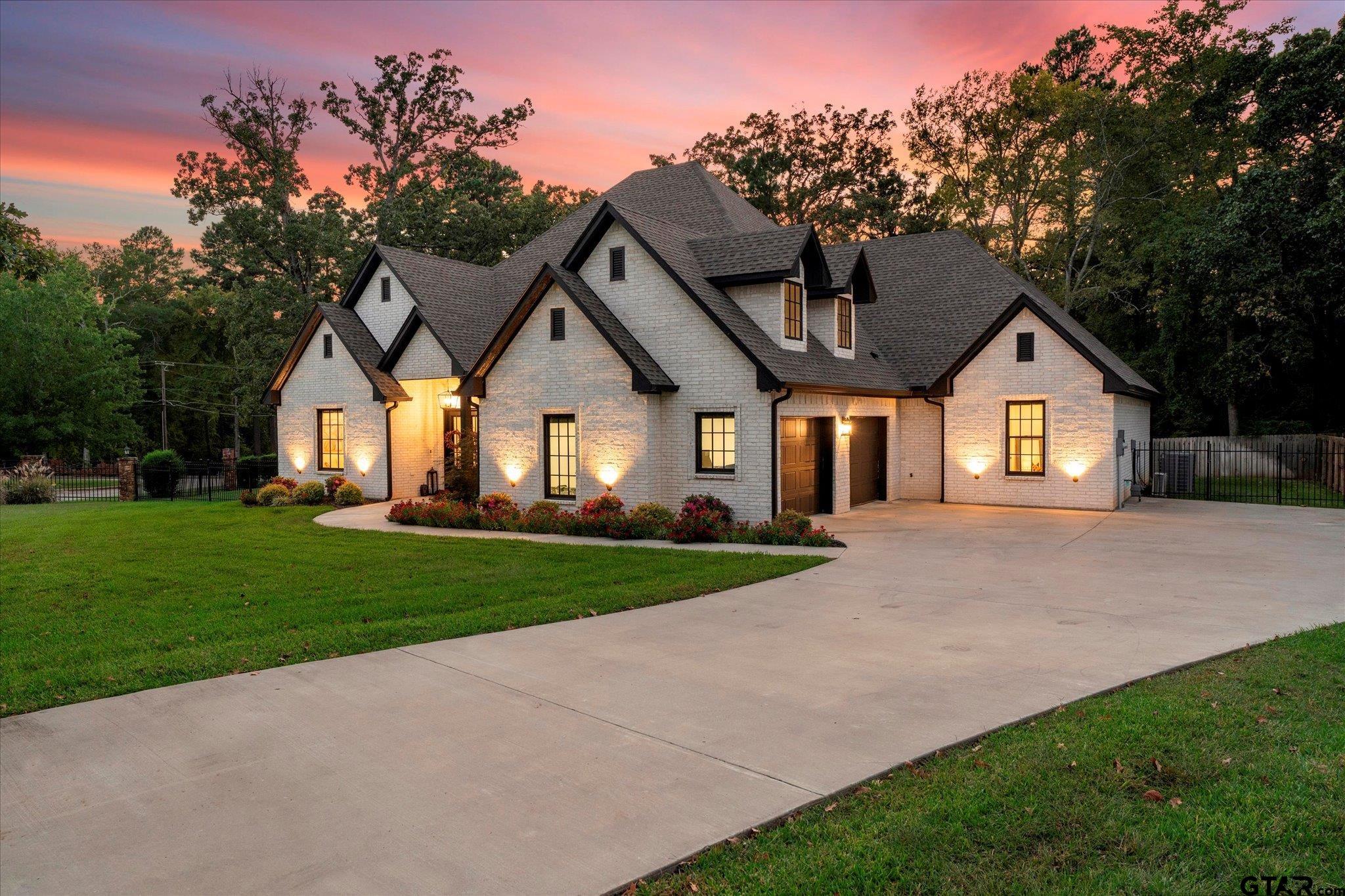 4301 Windrush Boulevard Longview, TX 75604 - Photo 2 of 36 a front view of a house with a yard and garage