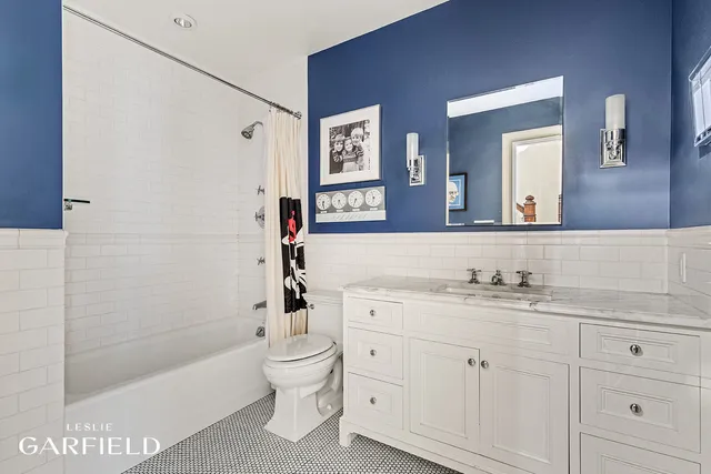 a bathroom with a bathtub shower sink vanity and toilet