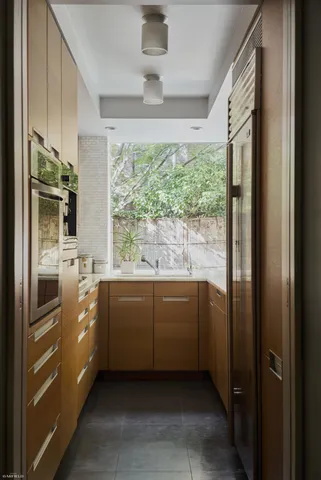 a kitchen with stainless steel appliances granite countertop a refrigerator a sink a stove and a refrigerator